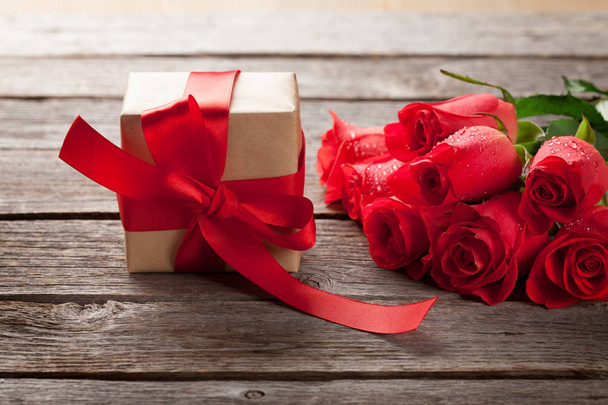 Valentines boîte cadeau et roses rouges sur fond en bois
 - Photo, image