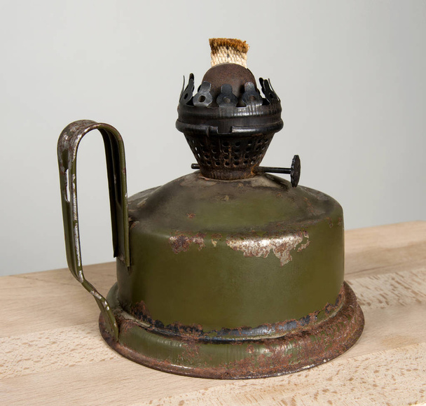 Old kerosene lamp on a wooden board. - Foto, afbeelding