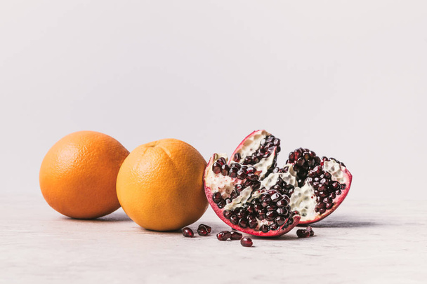 ripe delicious oranges and pomegranate on marble surface - Foto, imagen