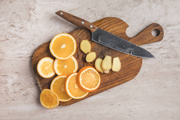 top view of cut oranges and ginger on wooden board - Foto, immagini