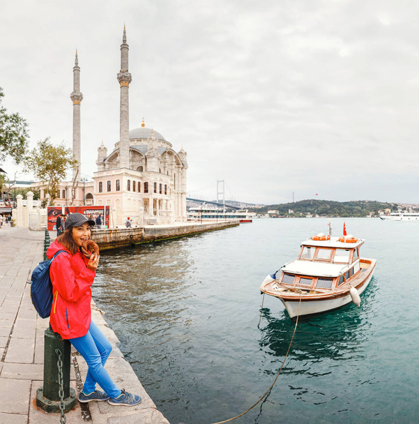 Девушка-туристка прогуливается возле достопримечательности Стамбула, города Ортакой
 - Фото, изображение