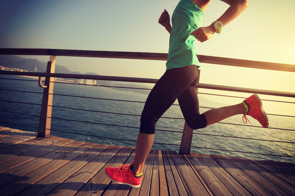 спортивная бегунья, бегущая по набережной на рассвете
 - Фото, изображение