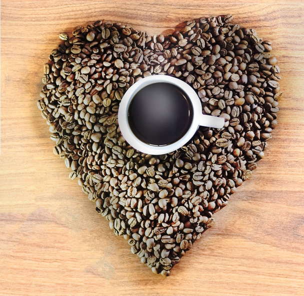 сердце кофейных зерен на деревянном фоне в центре чашки белого с кофе, с ним приходит пар
. - Фото, изображение