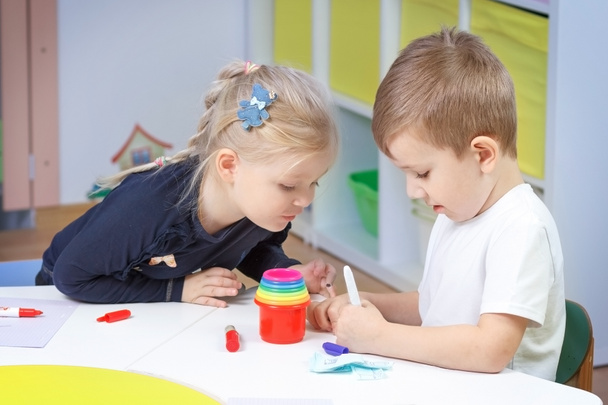 boy with a girl drawing together in kindergarten - Foto, afbeelding