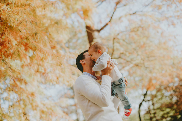 Jovem pai e bebê menino no parque de outono
 - Foto, Imagem