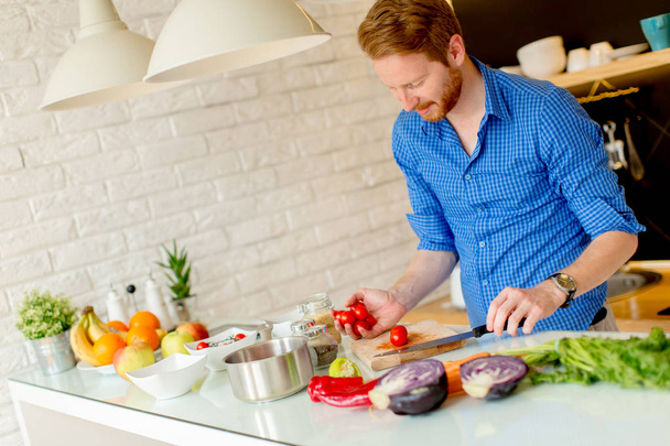 Redhair young man cooking food - Photo, Image