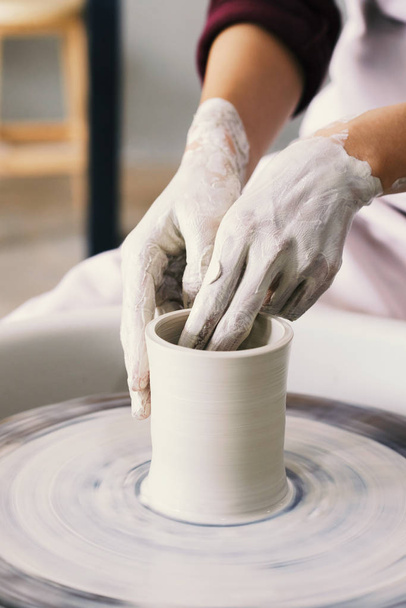 Vuile handen van potter vaas van klei maken - Foto, afbeelding