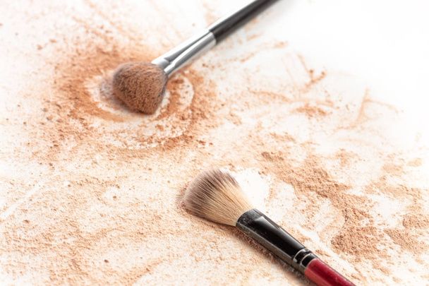 Close-up of crushed mineral shimmer powder golden color with makeup brush - Foto, imagen