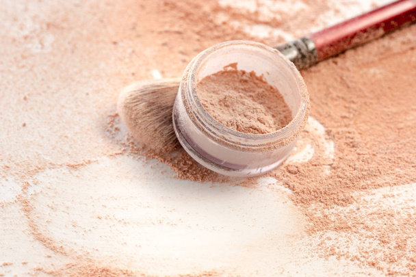 Close-up of crushed mineral shimmer powder golden color with makeup brush - Photo, Image