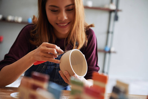 Молодая азиатка наслаждается процессом керамики в студии
 - Фото, изображение