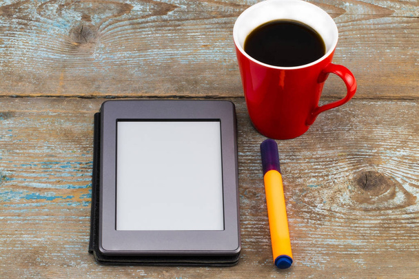 E-book reader and coffee cup on wooden table - Fotoğraf, Görsel