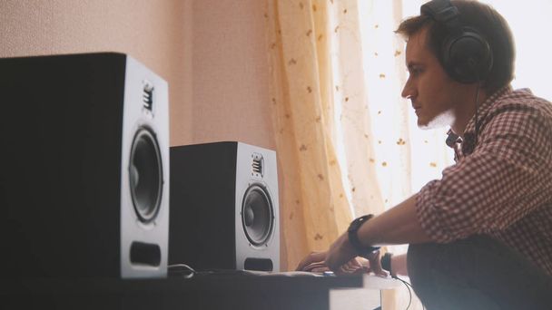 Молодой человек композитор сочиняет музыку на компьютере, звукорежиссер работает
 - Фото, изображение