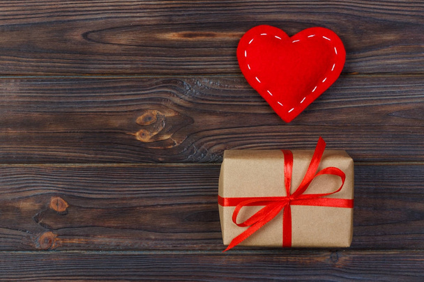 Coração e caixa de presente com fita vermelha no fundo de madeira
 - Foto, Imagem
