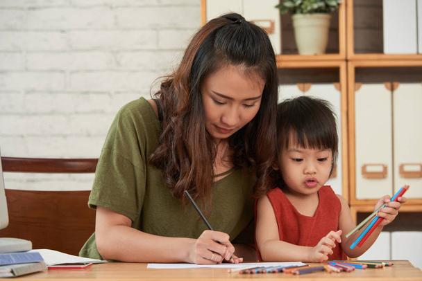 Азиатская молодая женщина и ее дочь рисуют вместе
 - Фото, изображение