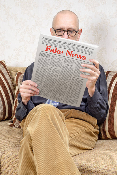 Mann liest Fake News in einer Tageszeitung - gefälschter Lorem-Ipsum-Text - Foto, Bild