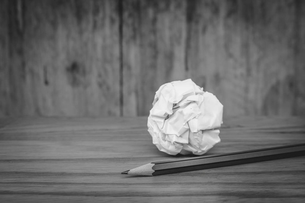 Business Creative and Idea Concept Lápiz usado con bola de papel blanco arrugado puesta en suelo de madera en imagen en blanco y negro
. - Foto, Imagen
