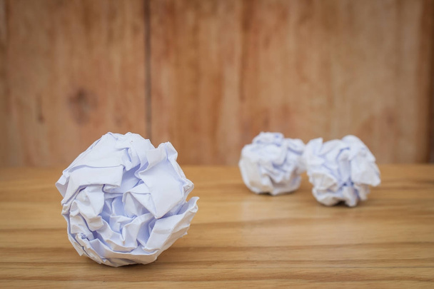 Üzleti kreatív és ötlet koncepció: zár megjelöl sok fehér gyűrött papír labda fel a fából készült foor. (Szelektív összpontosít) - Fotó, kép