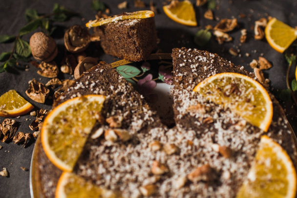 Mooie en lekkere chocolade taart met sinaasappel en moer op een donkere achtergrond - Foto, afbeelding