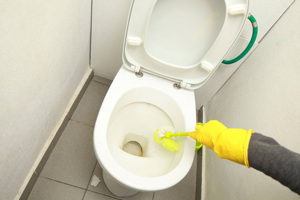 Χέρι-κίτρινα γάντια πλυσίματος τουαλέτα βρωμιά - Φωτογραφία, εικόνα