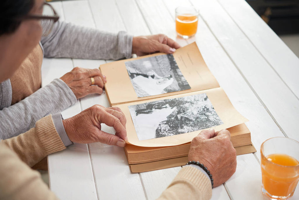 Hands of senior couple looking at old photos - Foto, Bild