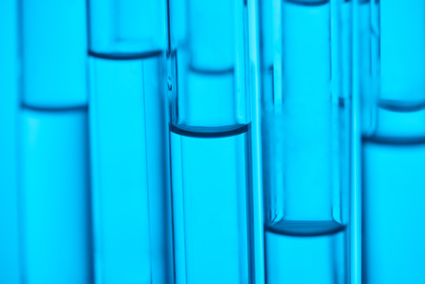 vue rapprochée des tubes en verre avec liquide pour essai scientifique sur bleu
 - Photo, image