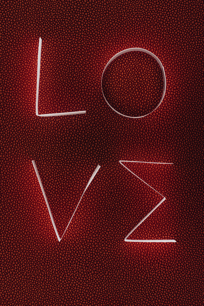 kelime kağıt çizgili koyu kırmızı yüzeyinde yapılan aşk - Fotoğraf, Görsel