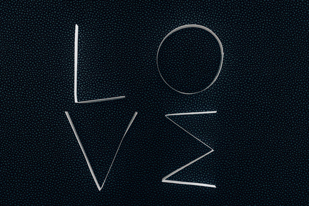 word LOVE made of paper stripes on black - Фото, изображение