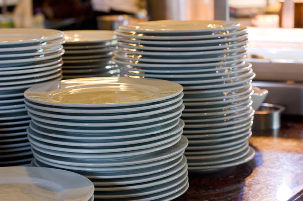 A stack of white porcelain big plates in a restaurant - 写真・画像
