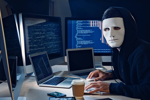 Masked man hacking server in dark room - Fotoğraf, Görsel
