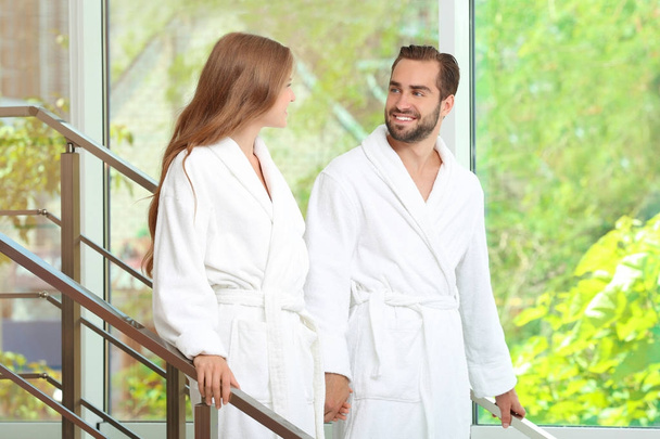 Young loving couple in bathrobes on stairs at home - Foto, Bild