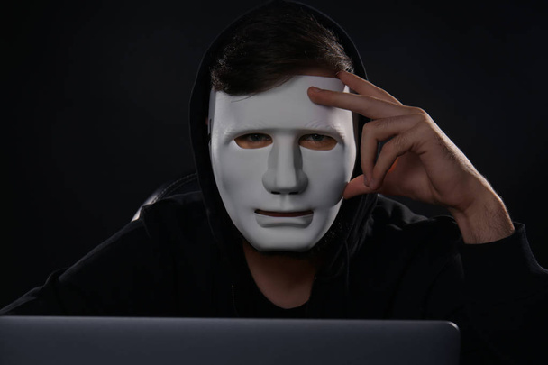 Masked man hacking server in dark room - Fotoğraf, Görsel