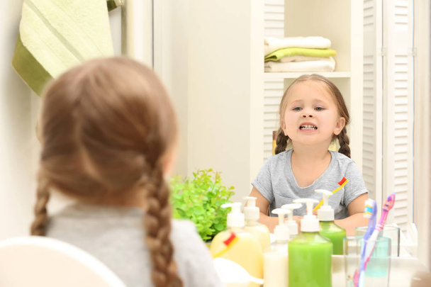 Cute little girl brushing teeth in bathroom - Zdjęcie, obraz