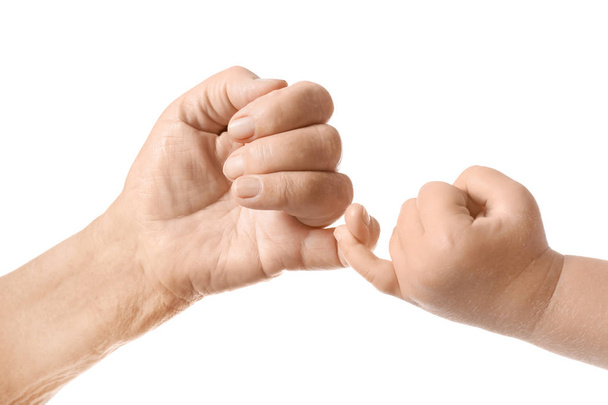 Hands of baby and elderly man making pinkie promise on white background - Fotoğraf, Görsel