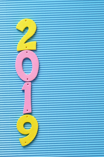 青色の背景にピンクと黄色の数字で 2019 - 写真・画像