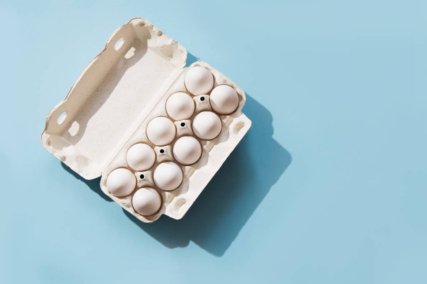 White eggs in the package on blue. Top view. - Φωτογραφία, εικόνα
