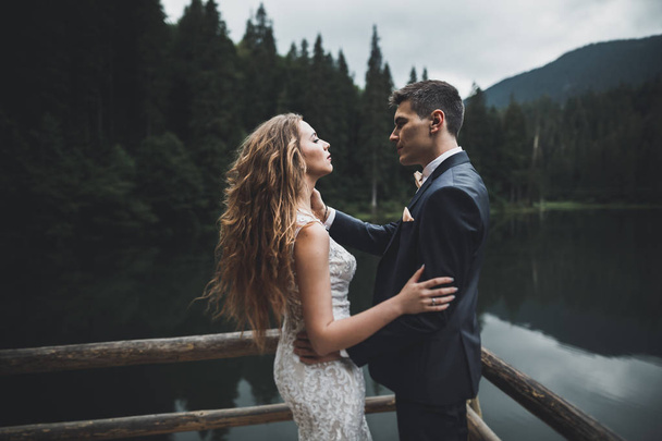 Beautiful gorgeous bride posing to groom and having fun, luxury ceremony at mountains with amazing view, space for text, wedding couple - Valokuva, kuva