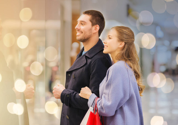 happy young couple with shopping bags in mall - Φωτογραφία, εικόνα