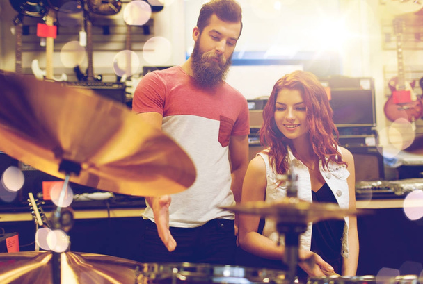 couple of musicians with drum kit at music store - Foto, Imagem