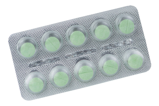 groene medische tablet in blisterverpakking op wit - Foto, afbeelding