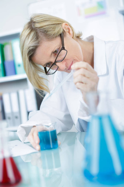 concentrated scientist doing scientific experiment in laboratory - Foto, Bild