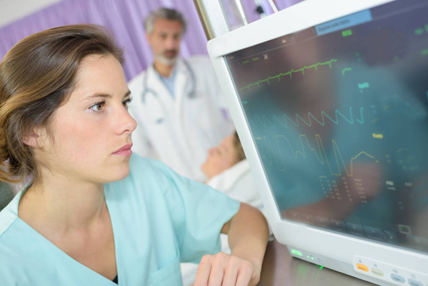nurse checking cardiogram report from electrocardiograph - Fotó, kép