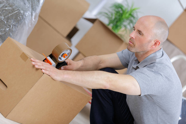 man is packing and using an adhesive tape - Photo, image