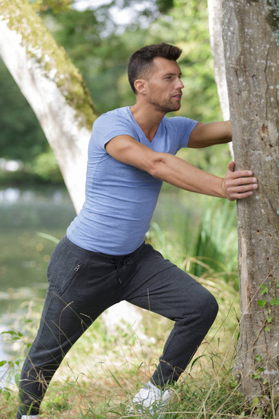 handsome man exercising in forest - Photo, Image