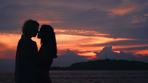 Cople φιλιά σιλουέτες μπροστά στον ωκεανό ηλιοβασίλεμα - Πλάνα, βίντεο