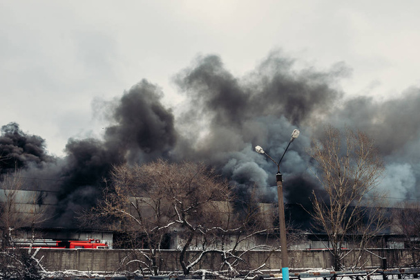 Ipari raktár vagy gyár, rengeteg füst és a lángok tűz - Fotó, kép