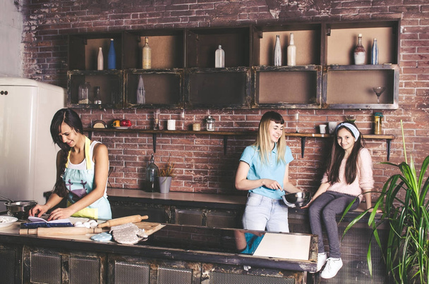 Young girls having fun on loft style  kitchen while preparing  - 写真・画像