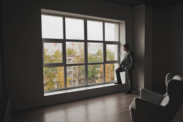 Portrait of a man standing next to a huge window 143. - Fotografie, Obrázek