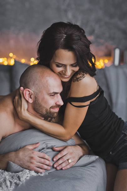 The girl gently hugs the neck, a bald beefy man 88. - Photo, Image