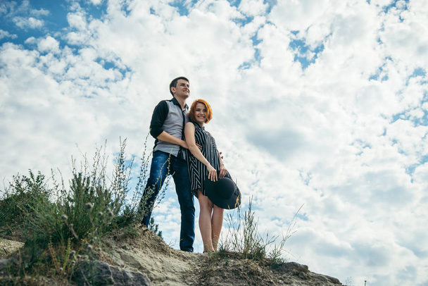 jonge man met vrouw staat op de heuvel en kijkt rechtdoor - Foto, afbeelding