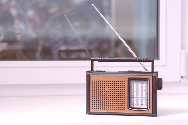 Stare radio retro brąz jest na białym parapecie pokoju z anteny kierunkowe - Zdjęcie, obraz